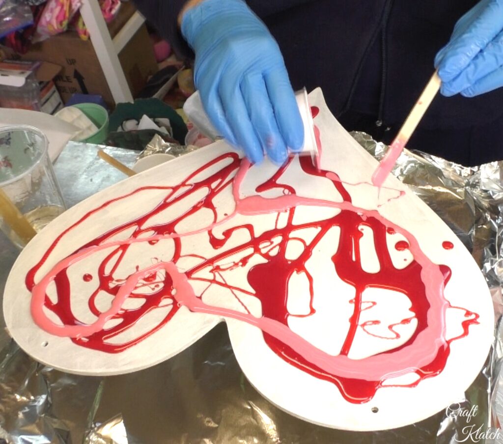 Pour pink resin onto heart art