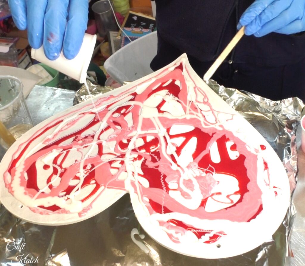 Pour white resin over red and pink resin on heart