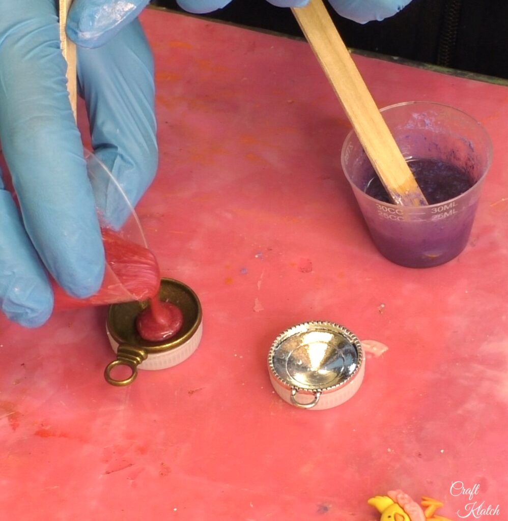 Pouring pink resin into bronze bezel