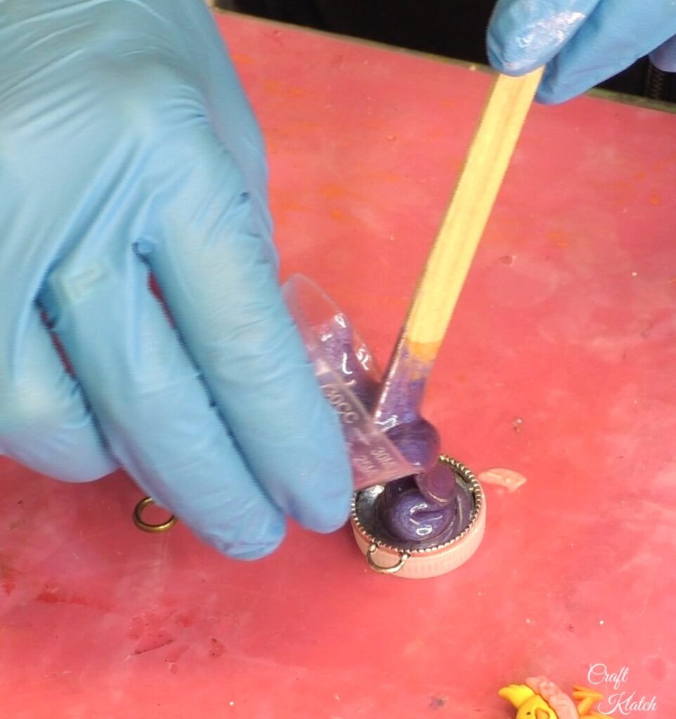 Pouring purple resin into silver bezel for the cute chick charms