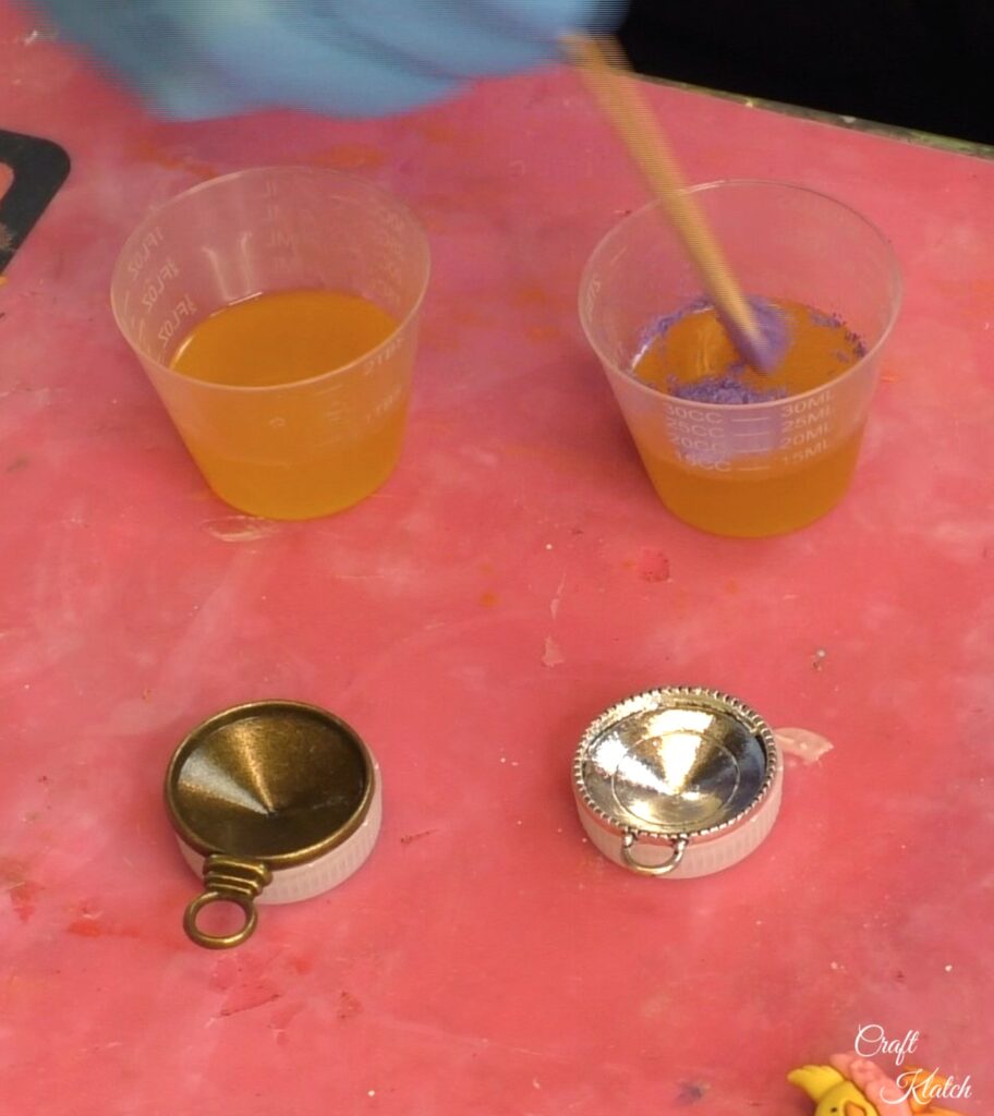 Mixing purple powdered pigment in the resin with bronze and silver bezels on bottle caps
