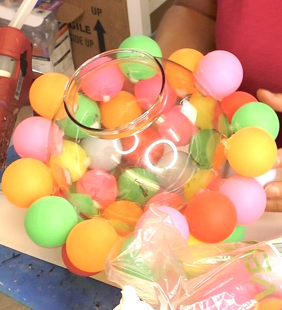 Open space left on the bottom of the glass globe covered with colorful ping pong balls