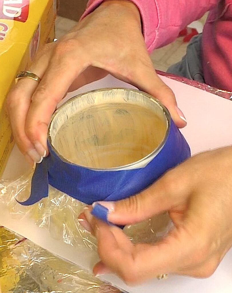 Use plastic wrap and painter's tape to cover the outside of the glass pumpkin decorations