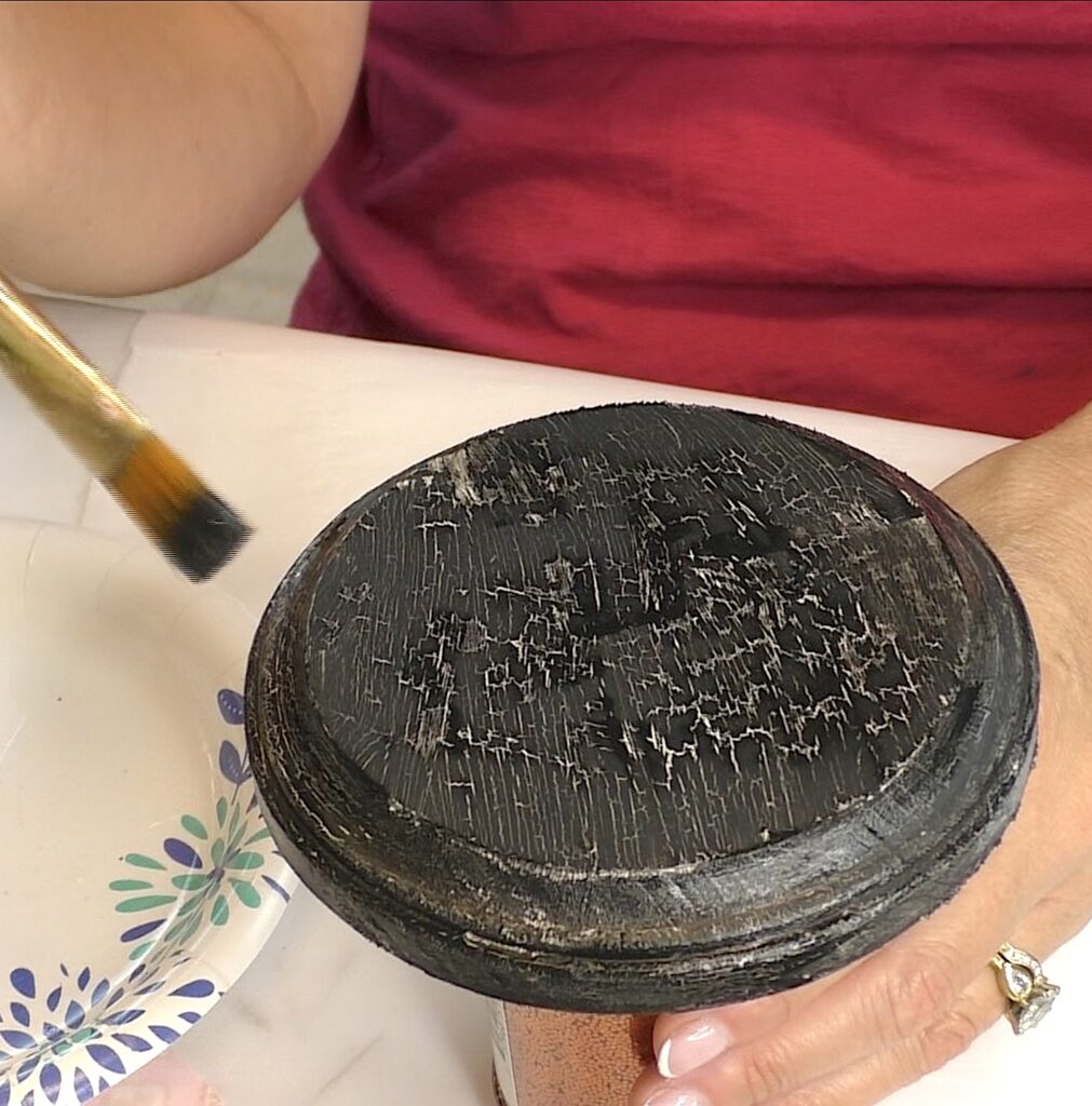 As the black paint dries, it crackles to show the beige color underneath