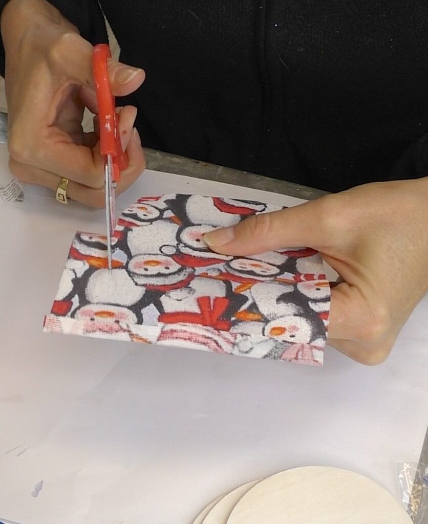 Trim Christmas penguin fabric to a little larger than the disc