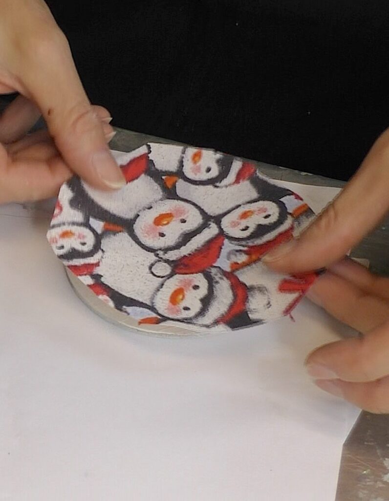 Place the penguin fabric onto the disc with the Mod Podge