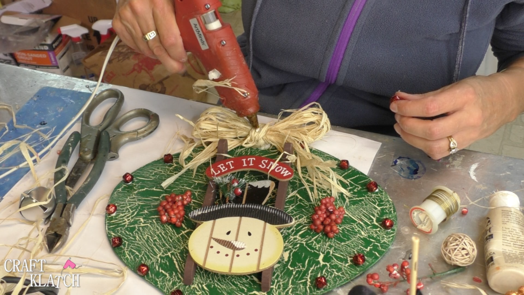 Adding hot glue to the middle of the raffia bow