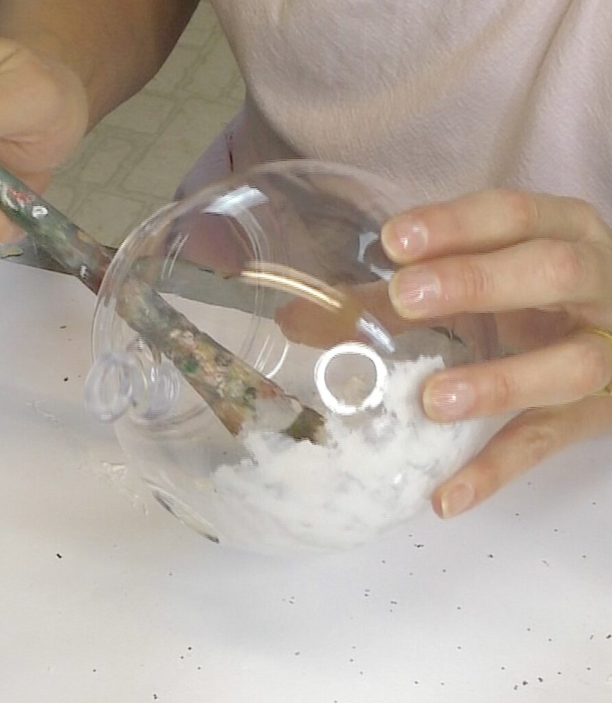 Dab the glue and glitter mixture onto the inside of the clear terrarium