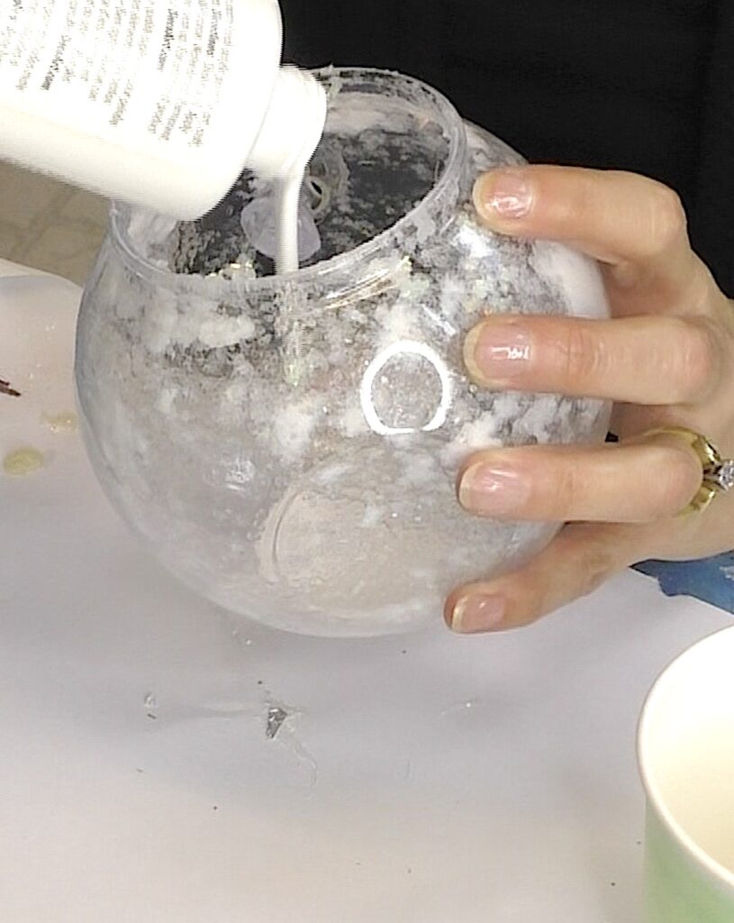 Pour white paint into the terrarium with the glue and glitter