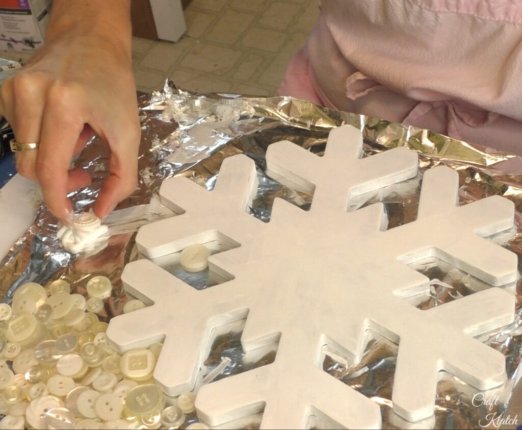 Dip white button into the glue for the snowflake decoration