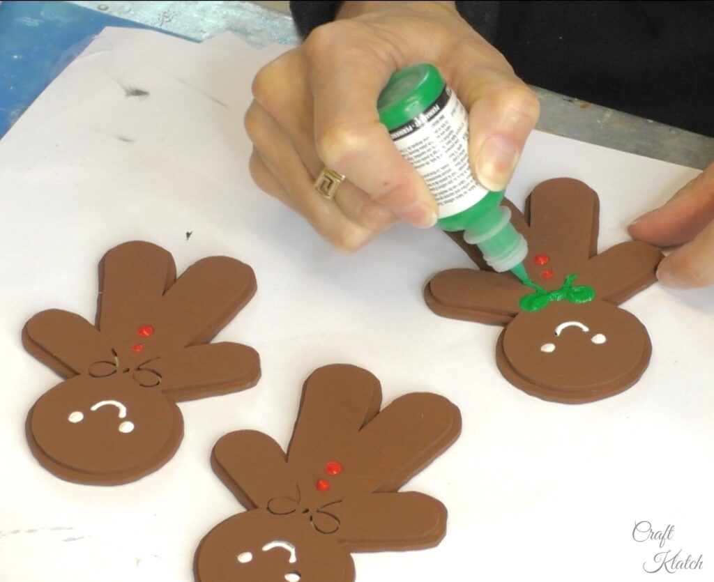 Decorate gingerbread men with green fabric paint