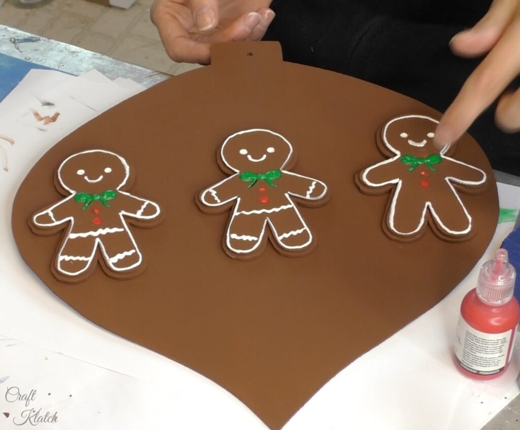 Three gingerbread men on brown Christmas ornament