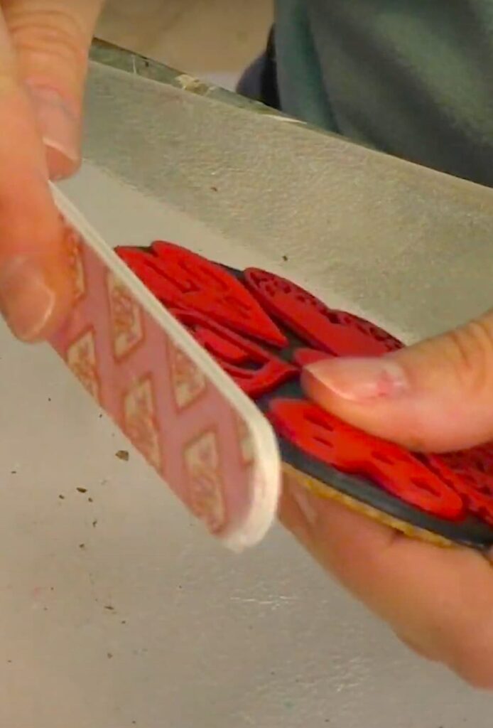 using an emery board to clean up the edges of the coaster