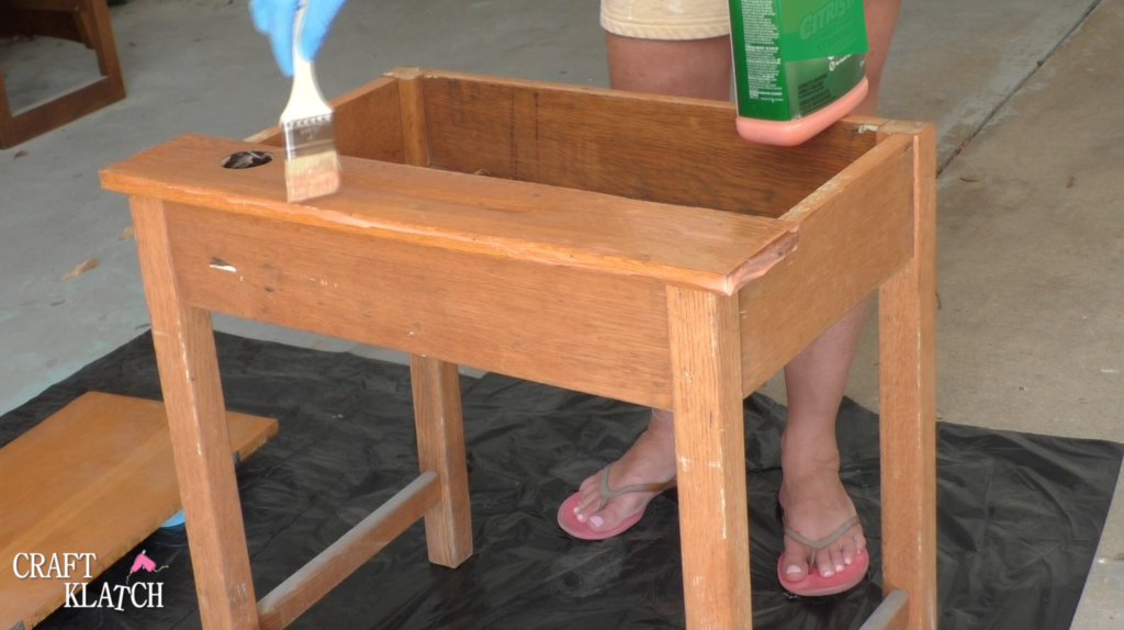 Brushing Citristrip stripper on an old desk