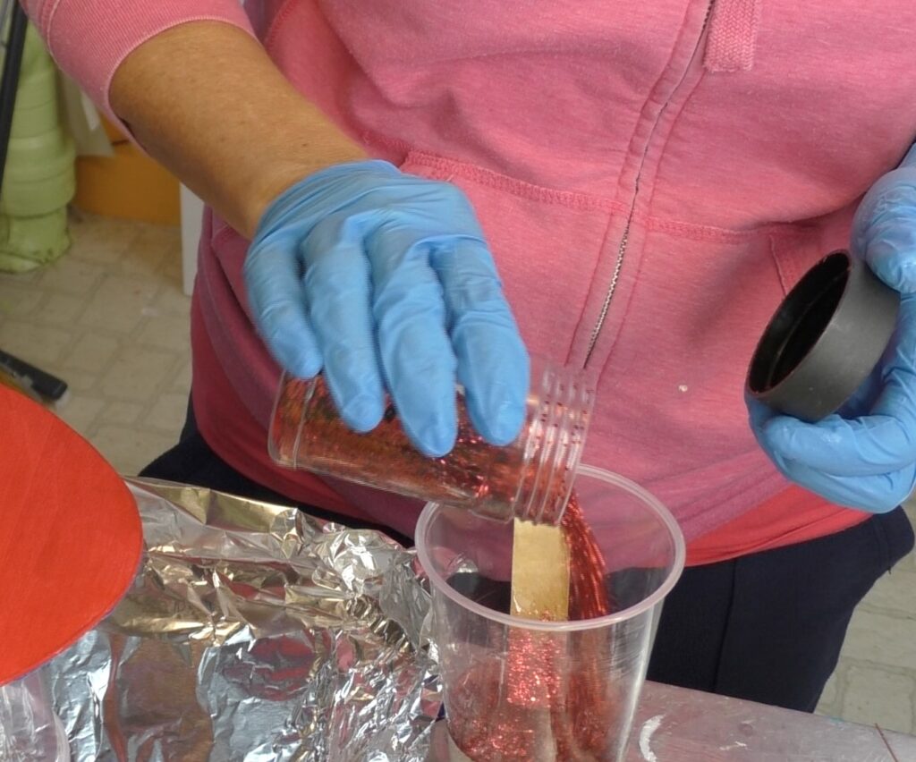 Pouring red glitter into resin