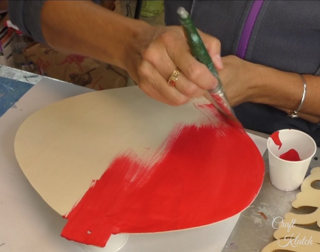 Unfinished Dollar Tree ornament being painted red