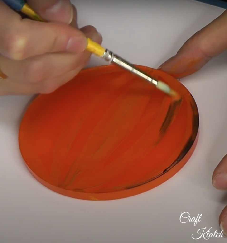 painting the lines on the orange pumpkin coaster