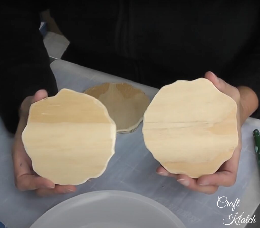 Hands holding two unfinished wood rounds 