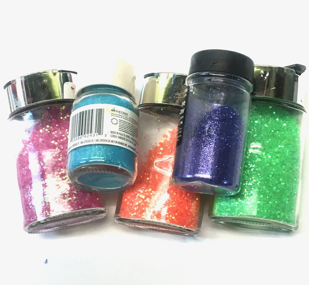 Jars of pink, blue orange and green glitter