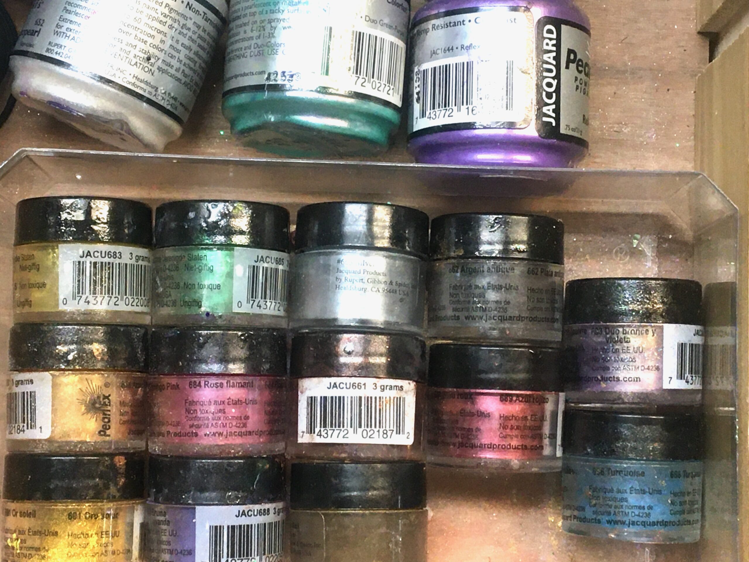 Jars of pigment powders in a variety of colors.
