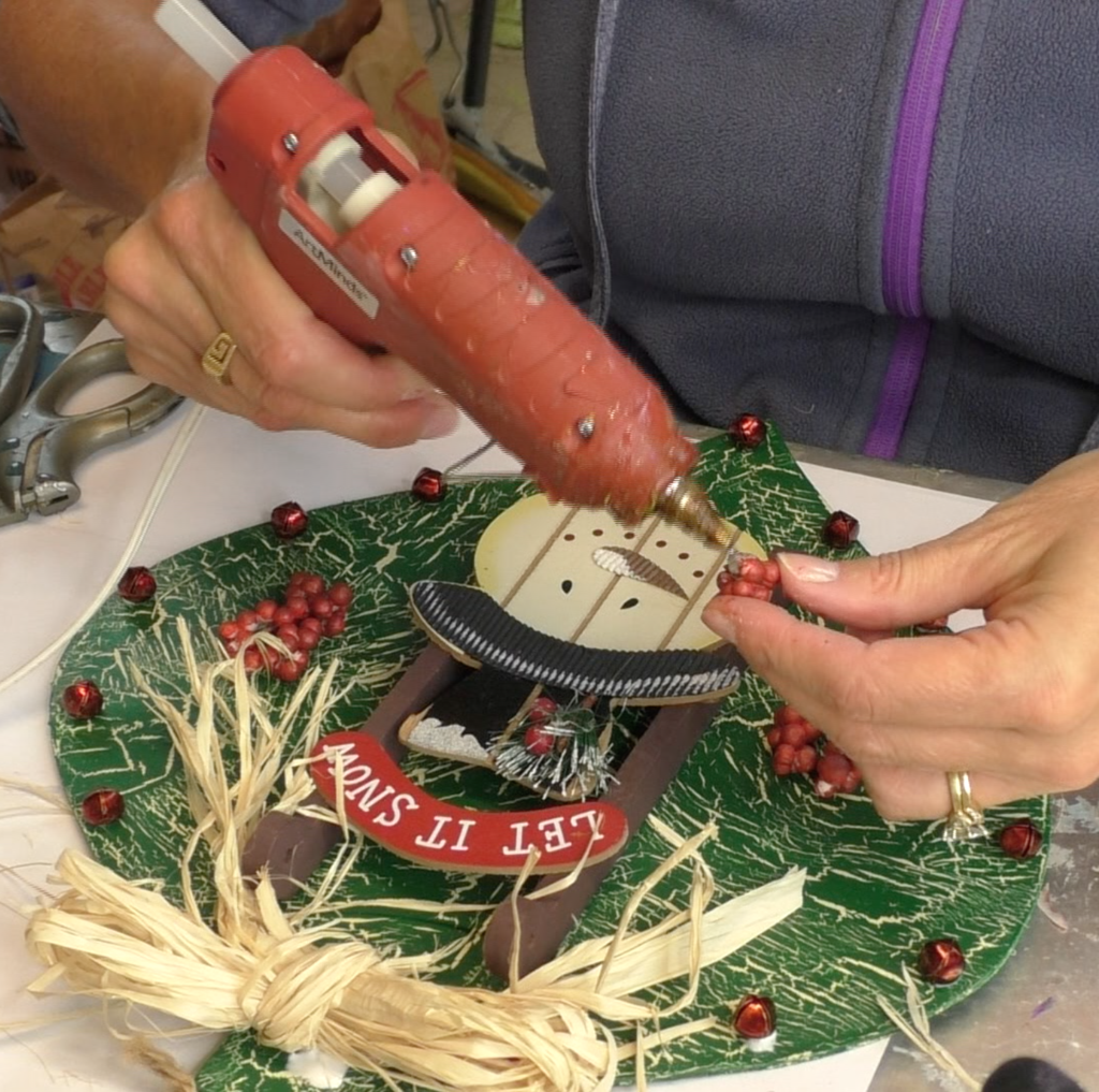 Gluing red berries onto ornament