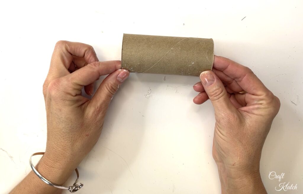 Holding empty toilet paper roll to make a Christmas ornament