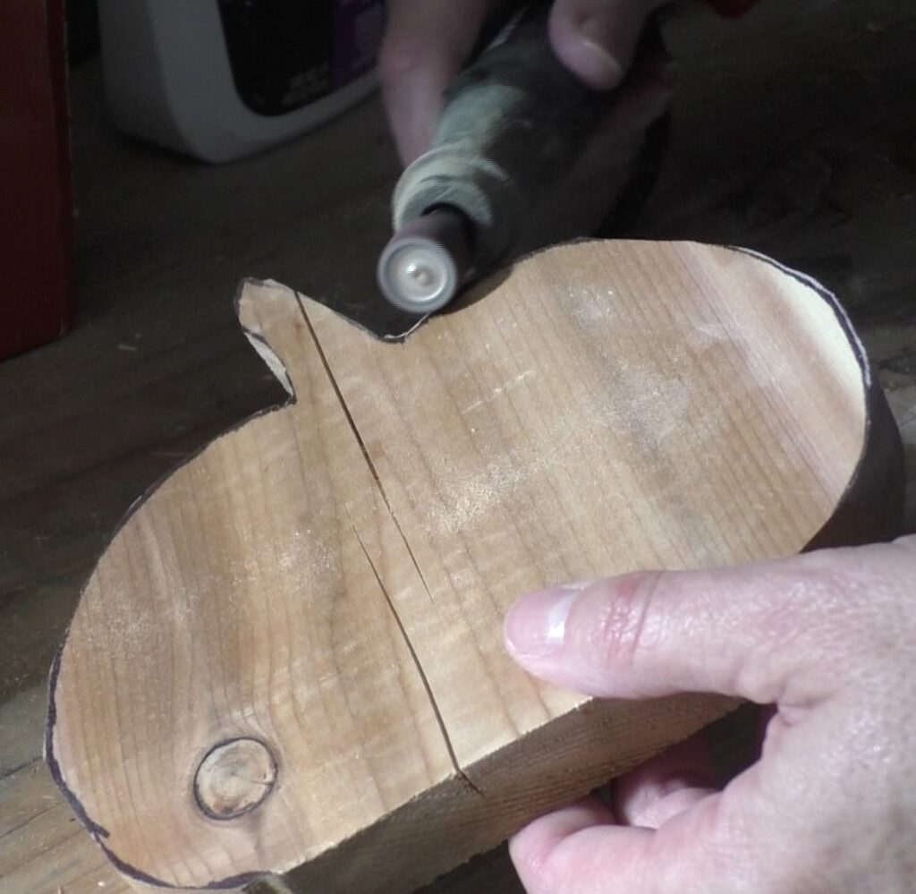 Using rotary tool to sand edges of wood pumpkin