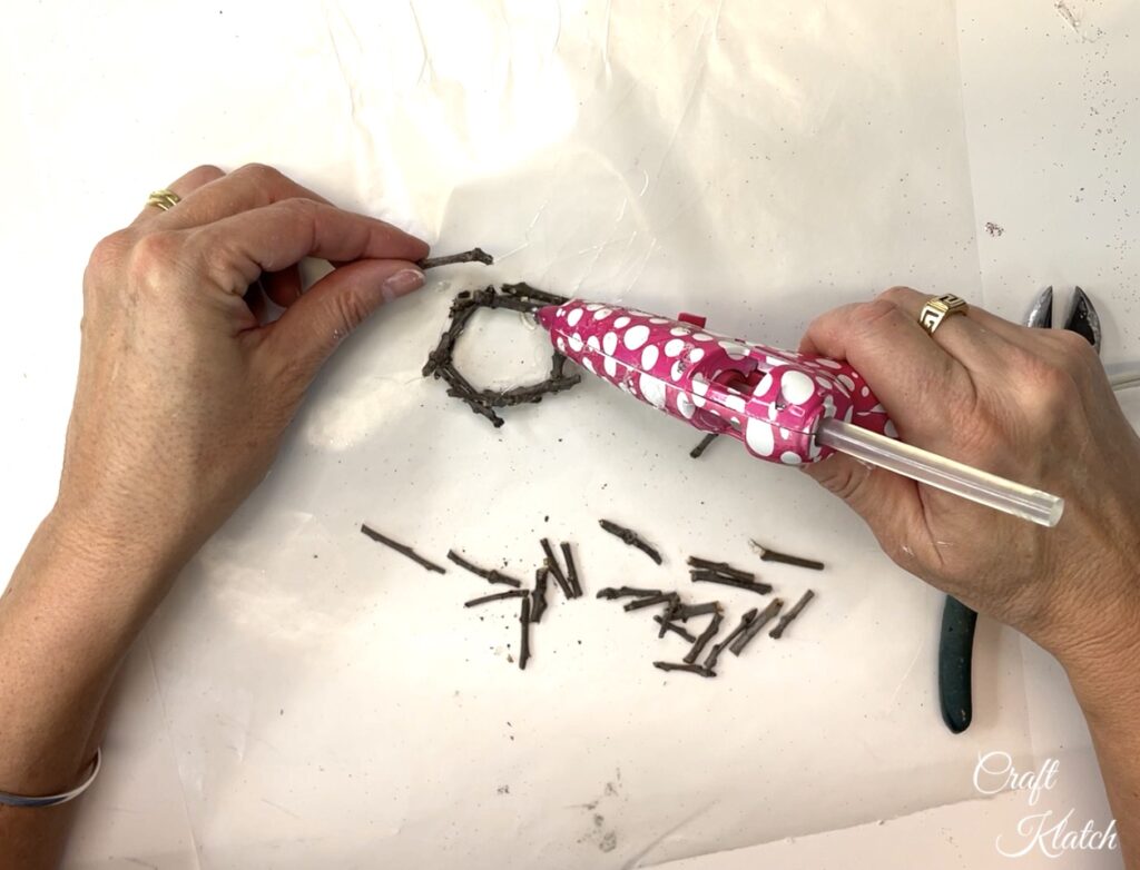 Hot glue twigs together to create birds nest for Christmas ornament