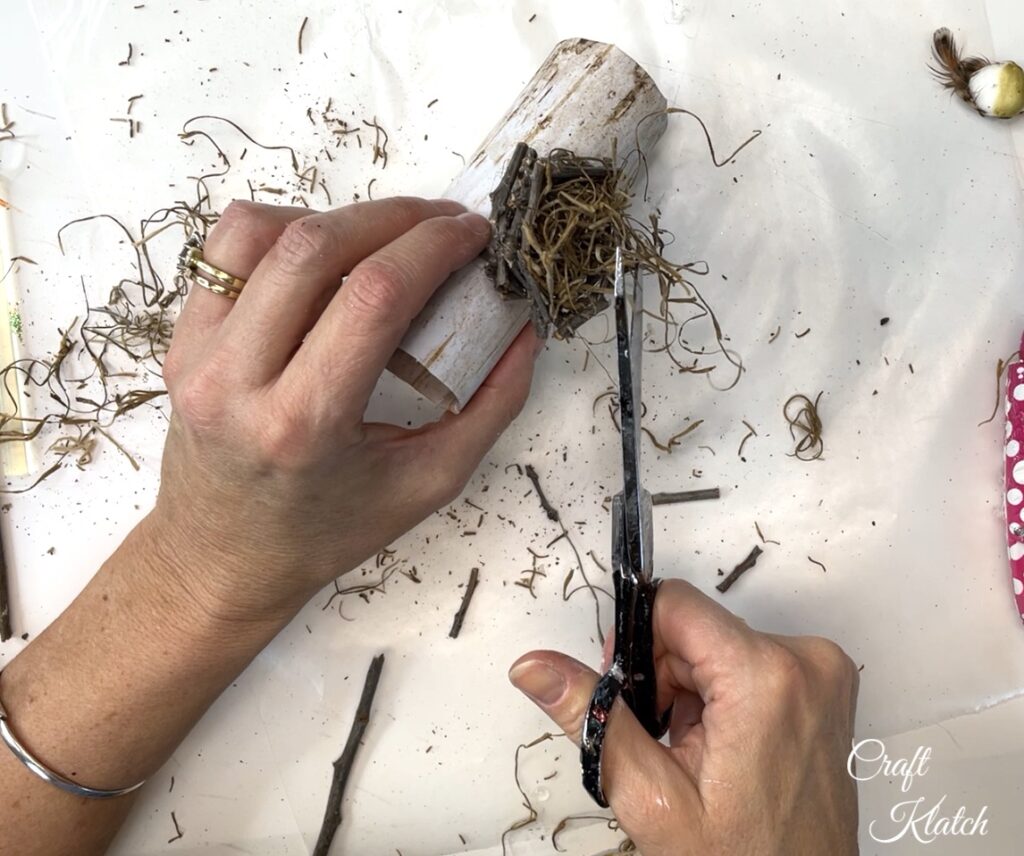 Hot glue and trim spanish moss in birds nest Christmas ornament