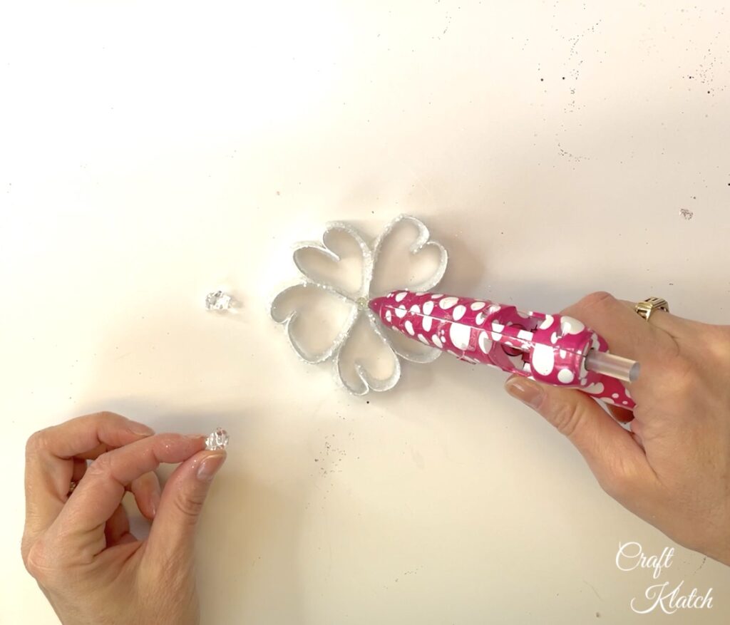 Glue gem vase filler pieces to the center of the paper snowflake