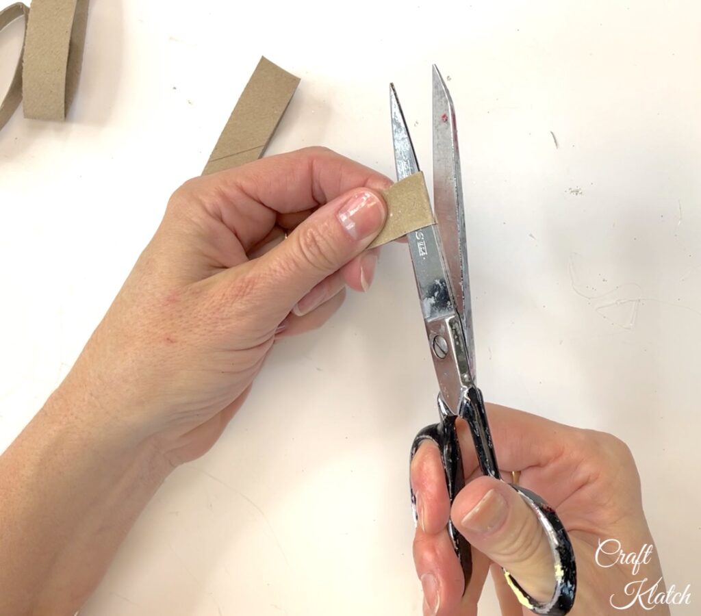 Cut open one end of toilet paper roll strips