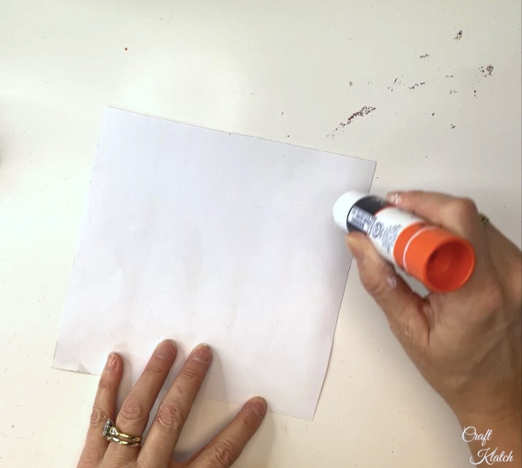 Add stick glue to the back of the scrapbook paper