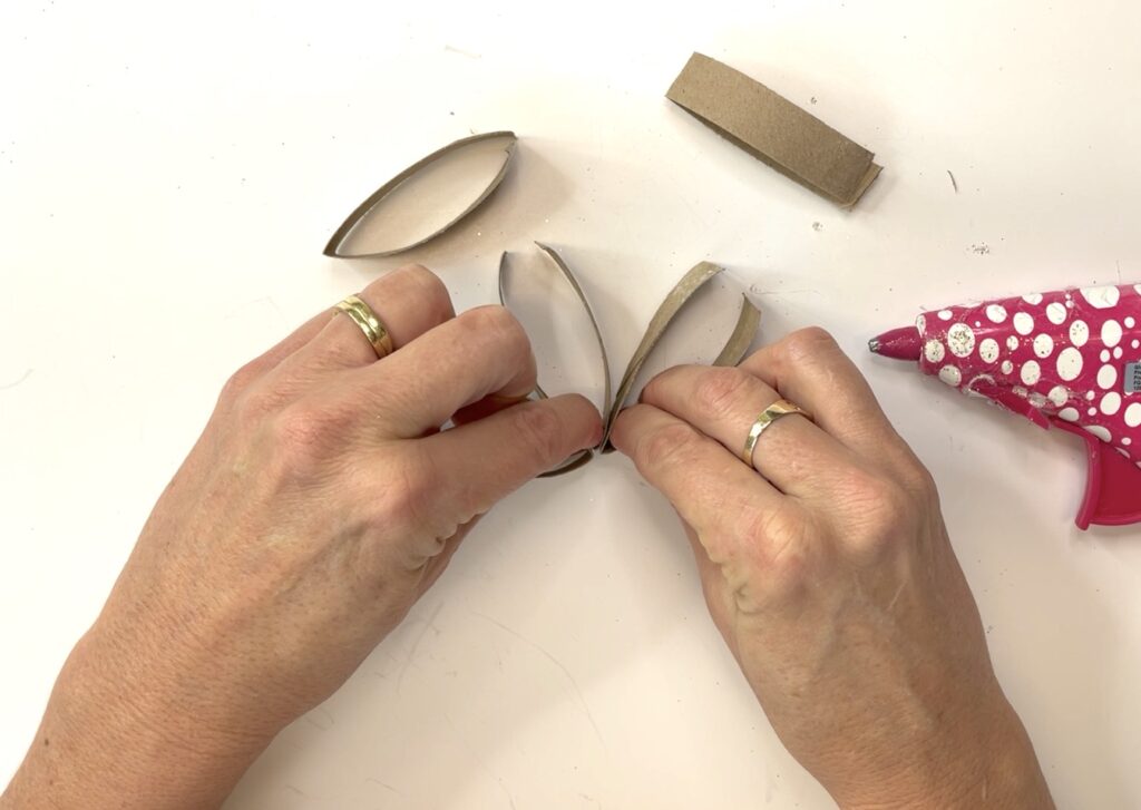 Hold toilet paper roll pieces together while hot glue cools