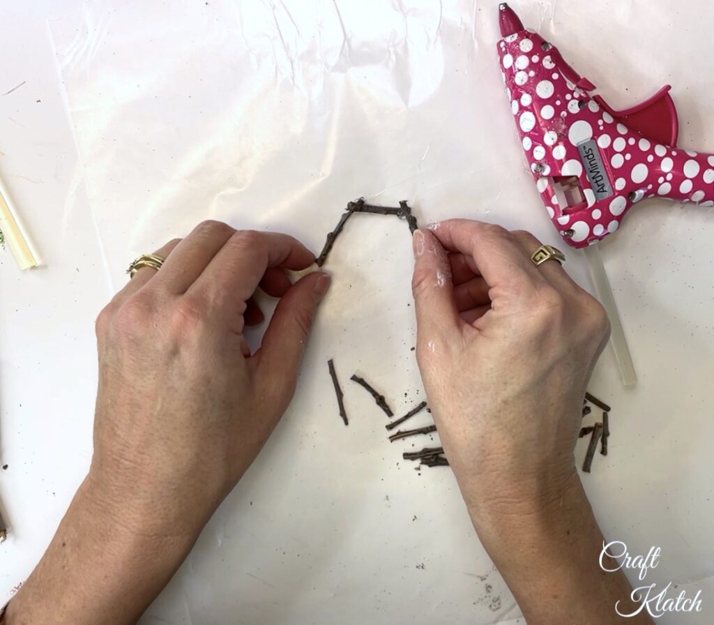 Hot glue twigs together to build a birds nest