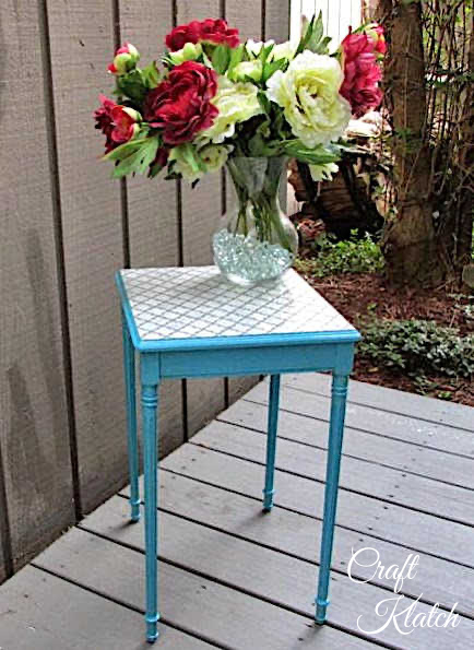 blue and white stenciled table with a vase of peonies 