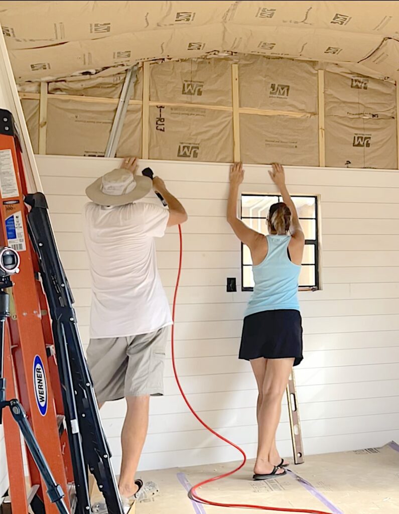 Dad and Mona hanging shiplap siding in the she shed