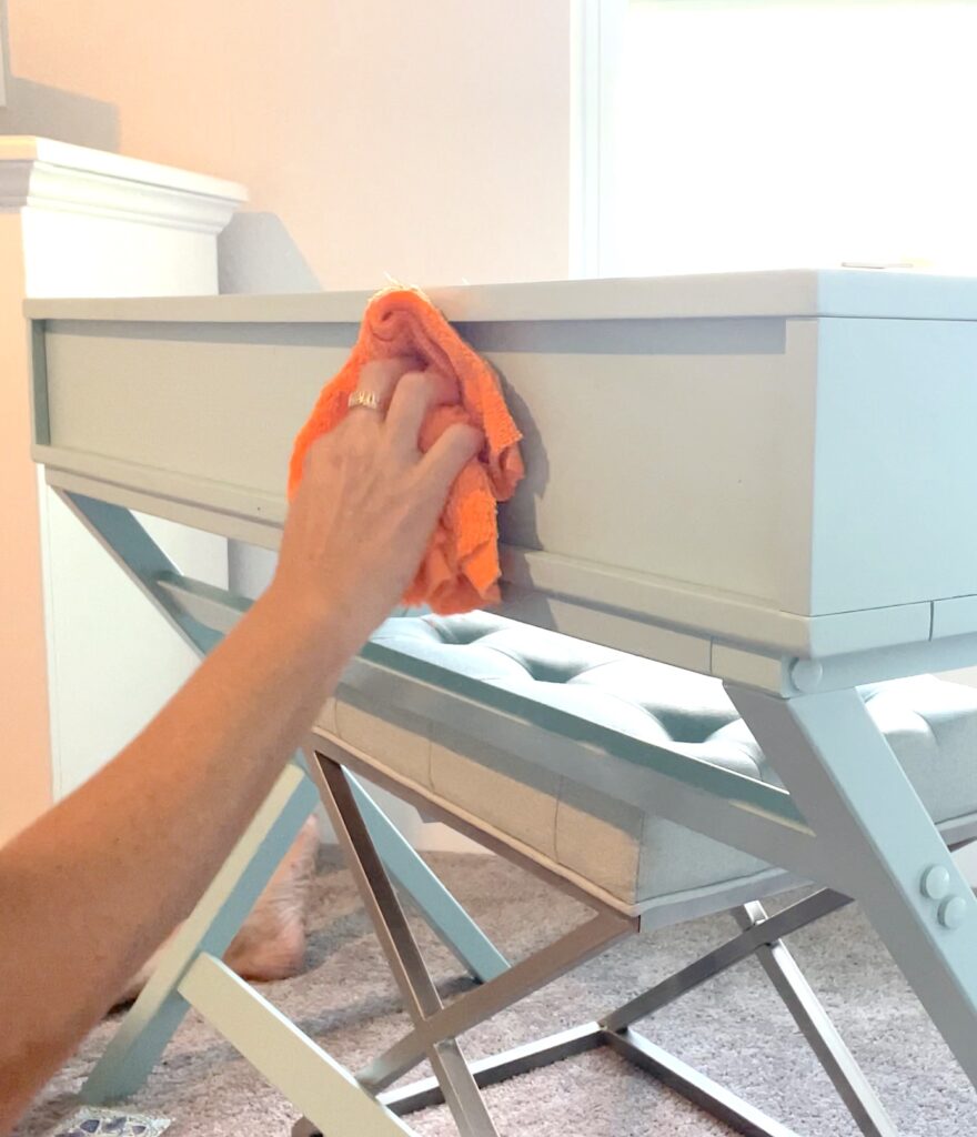 Cleaning surface of the desk with an orange micro fiber cloth
