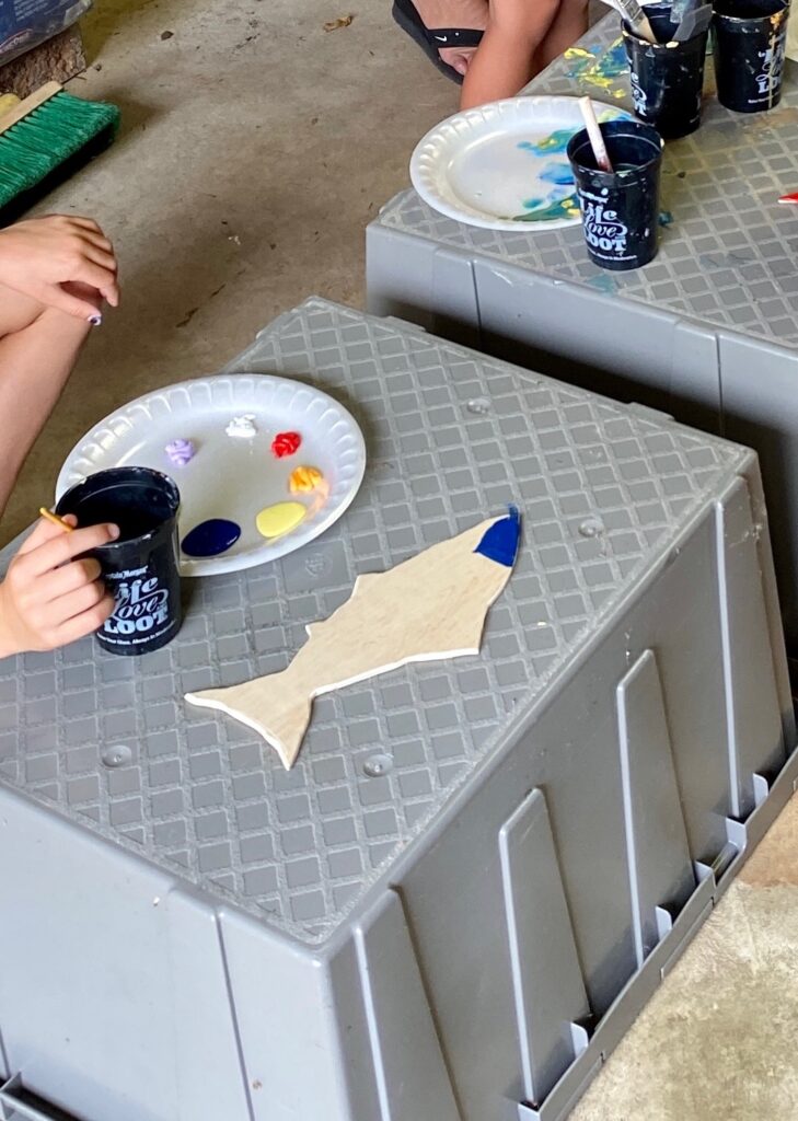 Wood fish being painted blue 