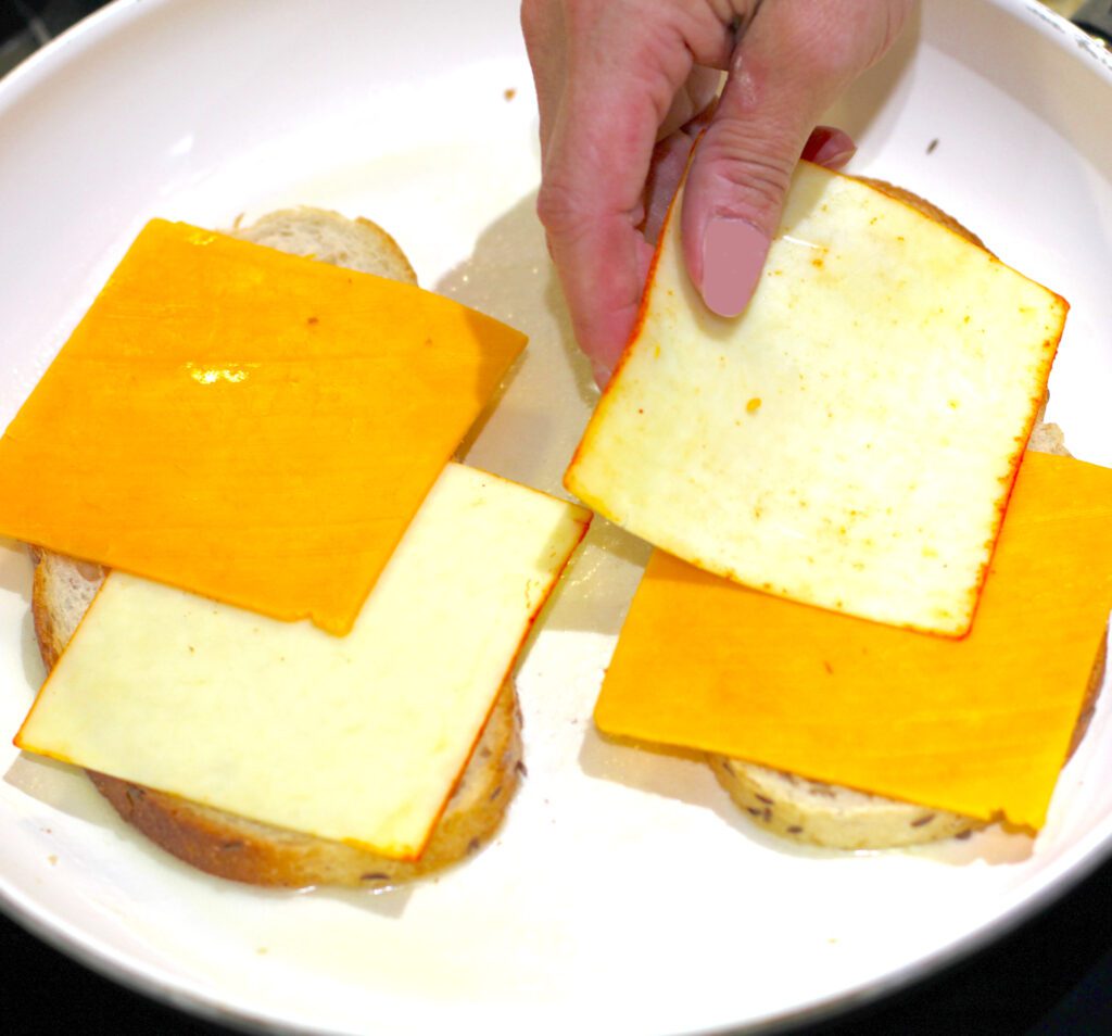 Add cheese to the bread for the grilled cheese sandwiches