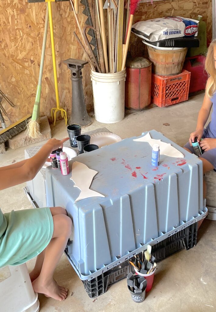 Gray bin set up as a table to paint fish