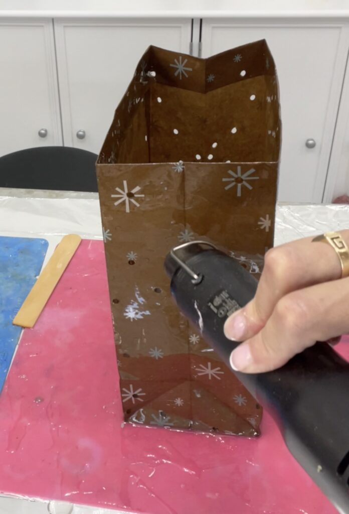 Use heat gun to pop bubbles in the resin