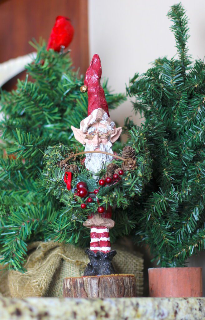 Wood carved elf among christmas trees