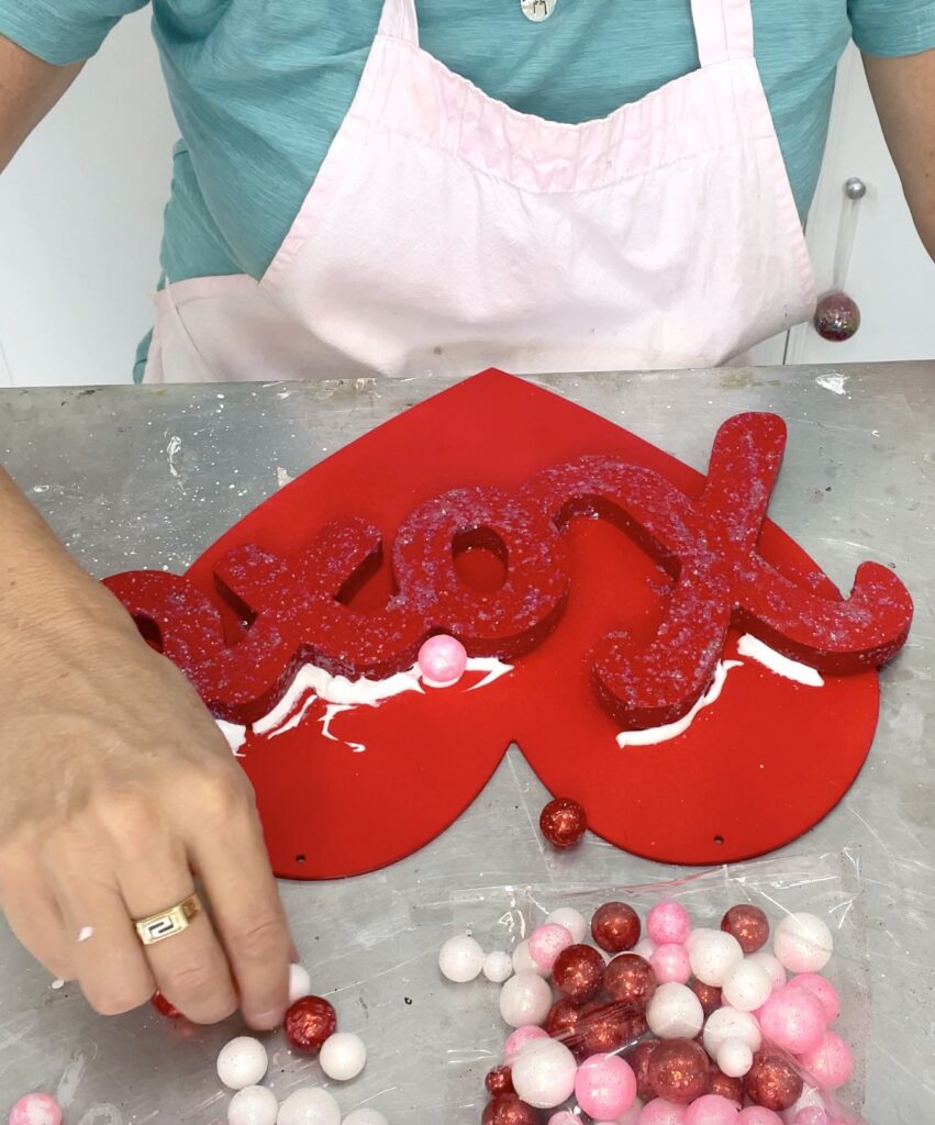 Gluing little styrofoam balls on the Valentine's Day decor