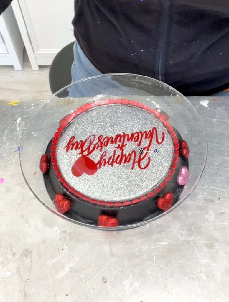 Gluing on glittered hearts onto Valentines dessert platter dollar tree craft