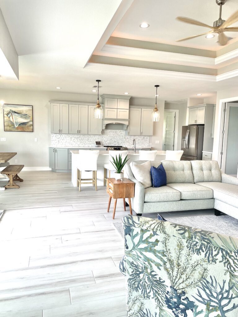 Open kitchen design with light gray and white cabinetry and white quartz countertops