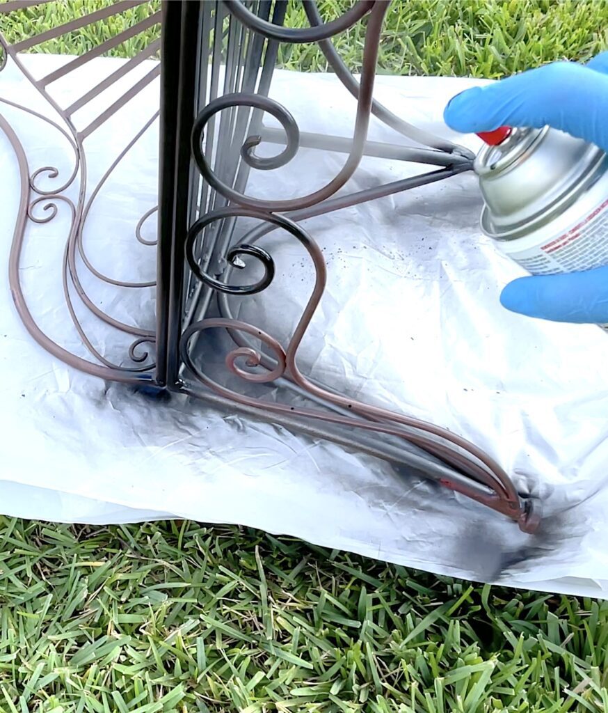 Spraying rust reformer on rusted furniture