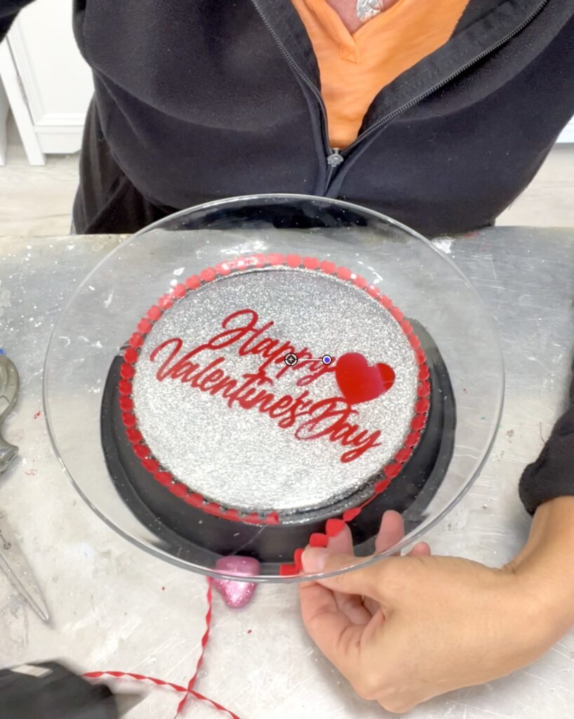 Using red dollar tree heart ribbon to trim out the bottom of the dessert platter