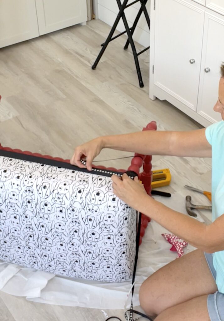 Adding black and white paw print ribbon around the ottoman furniture diy