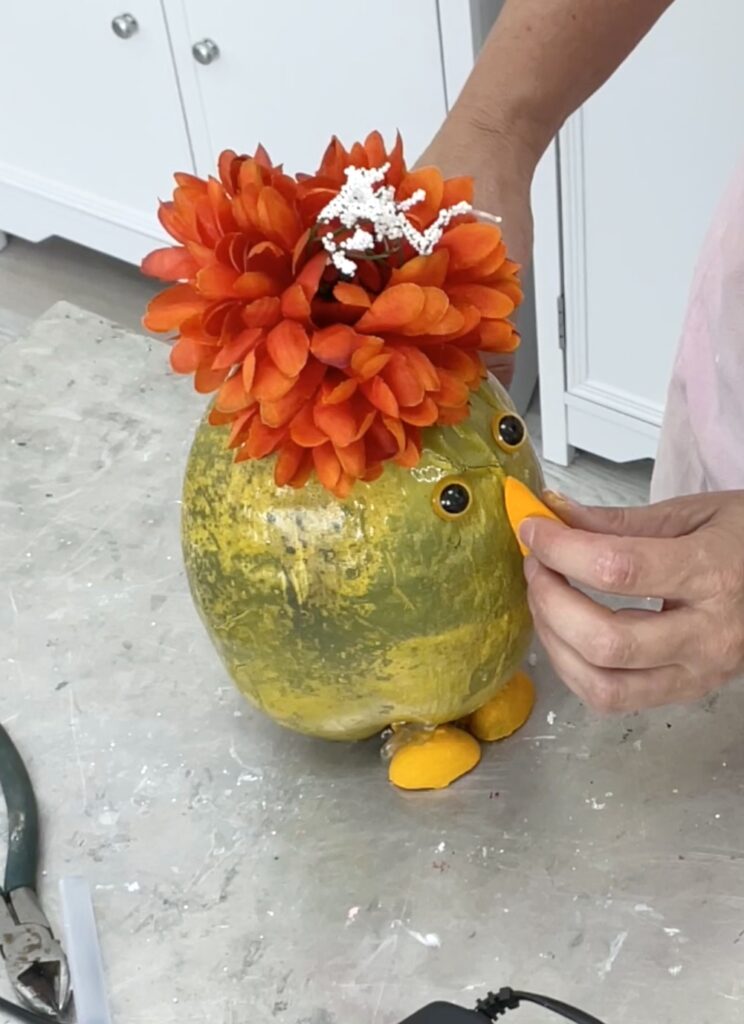 gluing orange felt beak onto the coconut chick craft