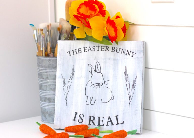 The Easter Bunny is real sign with carrots and yellow daffodils
